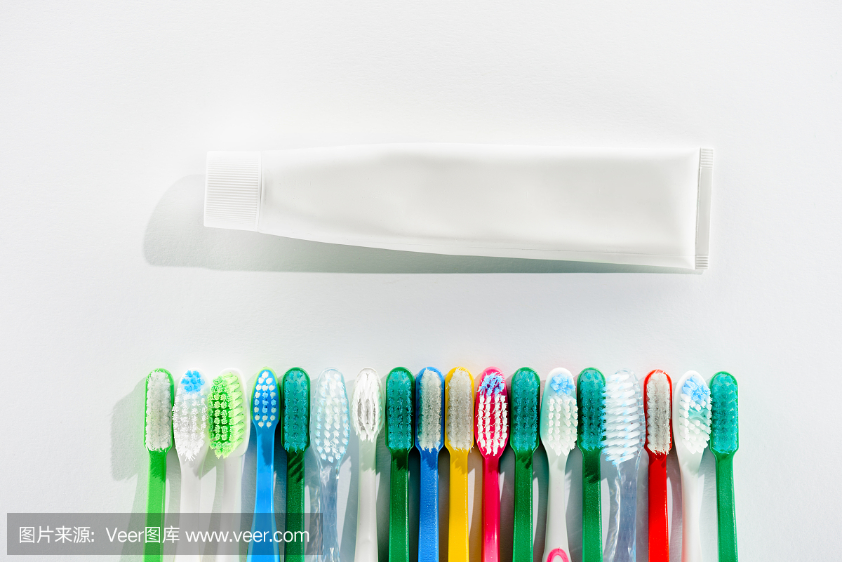 俯视图的彩色牙刷和牙膏管,在白色
